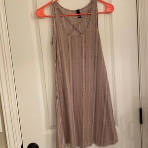 Light pink casual dress with light floral pattern and cross in front.